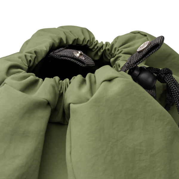 Detalle de la mochila de nylon con tapa y hebilla kabuki en color verde oscuro